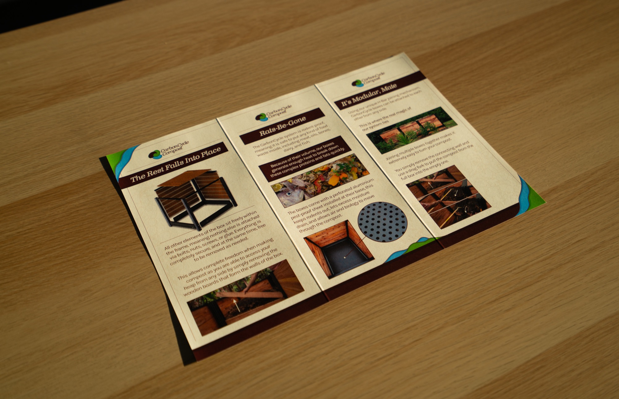 Carbon Cycle Compost brochure opened flat on a table, showing The Rest Falls Into Place, Rails-Be-Gone and It's Modular, Mate